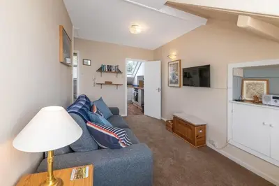 a living room with a blue couch and a lamp at Beach Front flat in Aberdovey in Aberdyfi