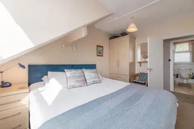 a bedroom with a white bed with a blue headboard at Beach Front flat in Aberdovey in Aberdyfi