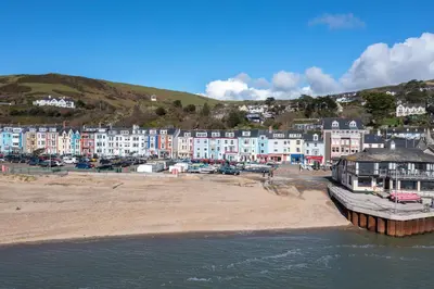 a beach with a group of houses and a town at Beach Front flat in Aberdovey in Aberdyfi