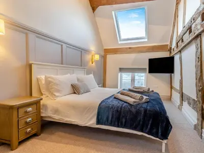 a bedroom with a bed with a tv on the wall at The Farmhouse - Uk48653 in Church Stretton