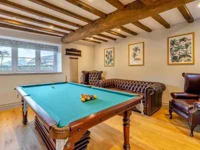 a living room with a pool table and leather furniture at The Farmhouse - Uk48653 in Church Stretton