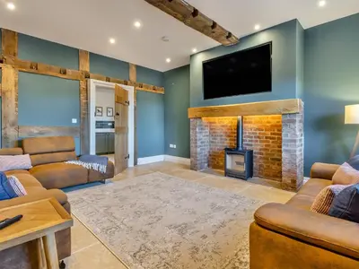 a living room with a fireplace and a flat screen tv at The Farmhouse - Uk48653 in Church Stretton