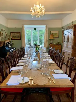 a long wooden table with chairs and a chandelier at Lower Buckton Country Living Big House near Ludlow 6 bedrooms sleep 12 in Leintwardine