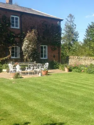 a house with white chairs in front of a yard at Lower Buckton Country Living Big House near Ludlow 6 bedrooms sleep 12 in Leintwardine