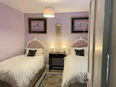 a bedroom with two beds and a table with two lamps at Lower Buckton Country Living Big House near Ludlow 6 bedrooms sleep 12 in Leintwardine