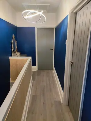 a hallway with blue walls and a hallway with a door at The House of Gnarrr in Machynlleth