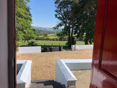 a view of a garden from a door at Secluded farmhouse with views in Cwrt-newydd