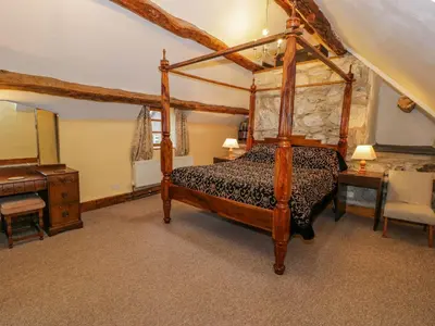 a bedroom with a canopy bed and a desk at Ysgubor in Machynlleth