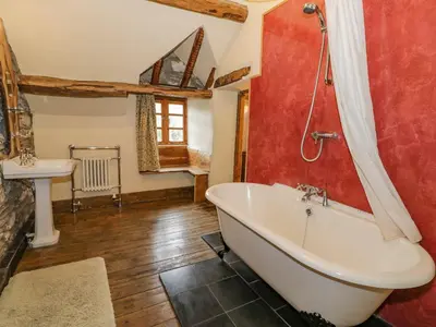 a bathroom with a bath tub and a sink at Ysgubor in Machynlleth