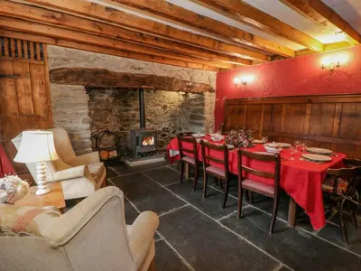 a dining room with a table and a fireplace at Ysgubor in Machynlleth