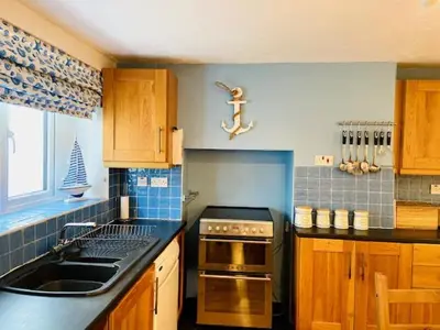 a kitchen with a sink and a stove top oven at Cosy 3 bedroom cottage by the sea in Aberdovey in Aberdyfi
