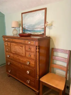 a dresser with a mirror on top and a chair at Cosy 3 bedroom cottage by the sea in Aberdovey in Aberdyfi