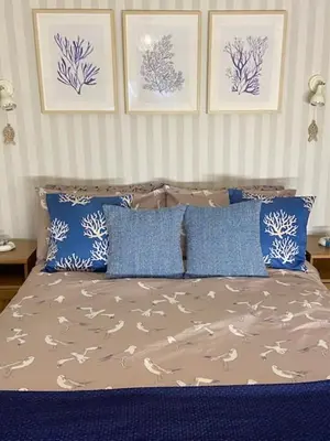 a bedroom with a bed with blue and white pillows at Cosy 3 bedroom cottage by the sea in Aberdovey in Aberdyfi