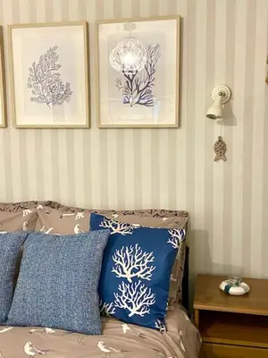 a room with a bed with pillows and pictures on the wall at Cosy 3 bedroom cottage by the sea in Aberdovey in Aberdyfi