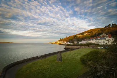 a view of a body of water with houses on a hill at Cosy 3 bedroom cottage by the sea in Aberdovey in Aberdyfi