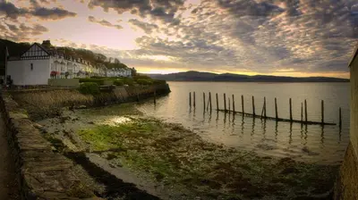 a view of a body of water with a building at Cosy 3 bedroom cottage by the sea in Aberdovey in Aberdyfi