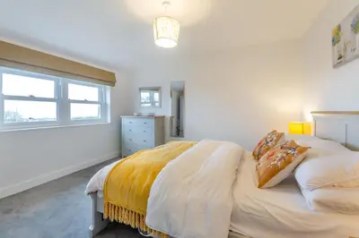 a white bedroom with a bed with a yellow blanket at 2 Bed in Llanfair oc-a30451 in Llanfair