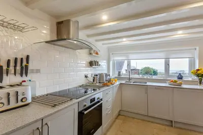 a kitchen with white appliances and a large window at 2 Bed in Llanfair oc-a30451 in Llanfair