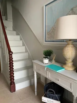 a stairway with a desk with a lamp and a staircase at Nant Llys - Spectacularly placed with sea views in New Quay