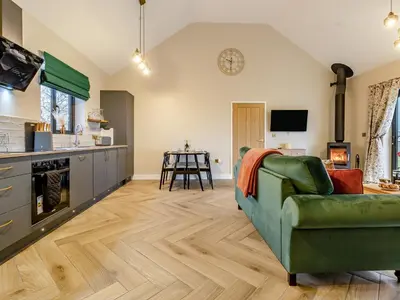 a living room with a green couch and a kitchen at Root - Uk47733 in Mochdre