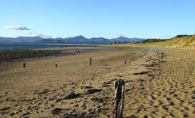 a sandy beach with a fence in the sand at Bryn Teg Barn in Dyffryn