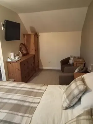 a bedroom with a bed and a couch and a television at The Pantry in Erwood