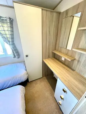 a small room with a bed and a desk at Gold Standard Luxury and Modern Static Caravan at Clarach Bay in Aberystwyth