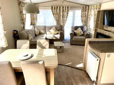 a living room with a couch and a table at Gold Standard Luxury and Modern Static Caravan at Clarach Bay in Aberystwyth