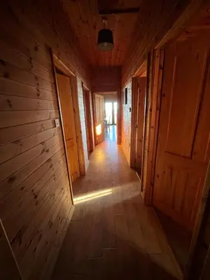 an empty hallway in a wooden house with a door at Red Kite Lodge in Clyro