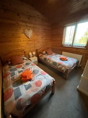 a bedroom with two beds in a log cabin at Red Kite Lodge in Clyro