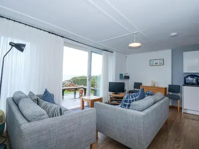 a living room with two couches and a large window at Ael Y Don in Harlech