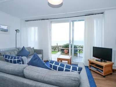 a living room with a couch and a flat screen tv at Ael Y Don in Harlech