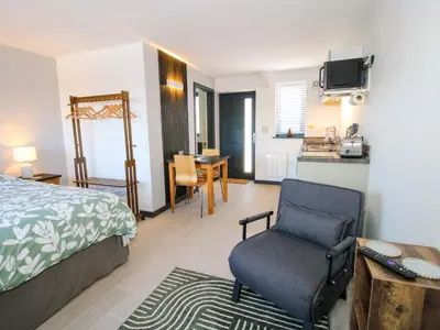 a bedroom with a bed and a chair and a kitchen at Stiper View Barn 2 in Shrewsbury