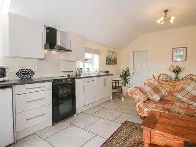 a kitchen and living room with a couch at Millstone Cottages - Millstone Cottage in Shrewsbury