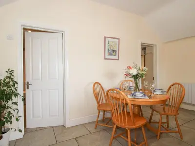 a dining room with a wooden table and chairs at Millstone Cottages - Millstone Cottage in Shrewsbury
