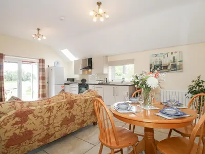 a living room and kitchen with a couch and a table at Millstone Cottages - Millstone Cottage in Shrewsbury