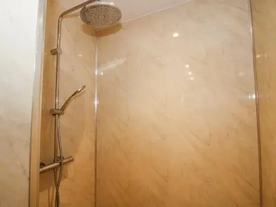a shower with a shower head in a bathroom at Millstone Cottages - Middle Cottage in Shrewsbury