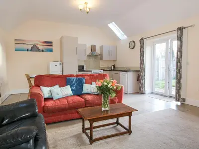 a living room with a red couch and a table at Millstone Cottages - Middle Cottage in Shrewsbury