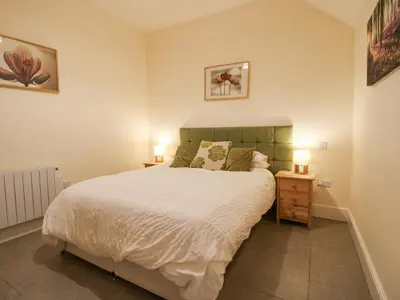 a bedroom with a large white bed with two lamps at Millstone Cottages - Middle Cottage in Shrewsbury