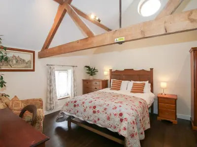 a bedroom with a large bed in a room at Millstone Cottages - Breidden View in Shrewsbury