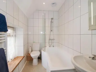 a bathroom with a tub and a toilet and a sink at Millstone Cottages - Breidden View in Shrewsbury