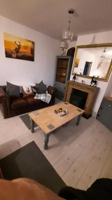 a living room with a couch and a coffee table at Conkers Cottage in Forden