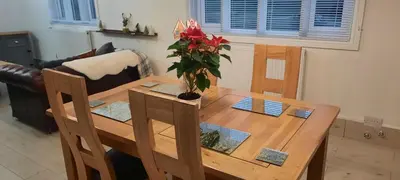 a wooden table with a vase of flowers on it at Conkers Cottage in Forden