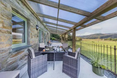 a patio with a table and chairs on a building at 2 Bed in Penmaenpool oc-m30050 in Arthog