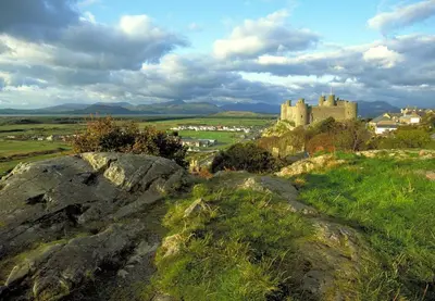 a castle on top of a hill with rocks at 2 Bed in Penmaenpool oc-m30050 in Arthog