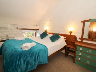 a bedroom with a bed with towels on it at Y Beudy in Llanybydder