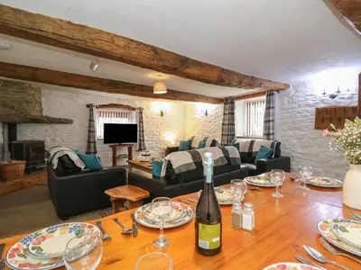 a living room with a table with a bottle of wine at Y Beudy in Llanybydder