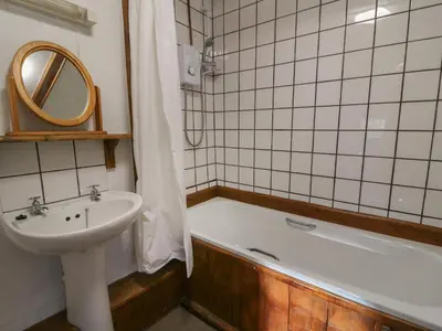 a bathroom with a sink and a bath tub next to a sink at Y Beudy in Llanybydder