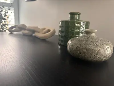 a table with a vase and a bottle on it at Barmouth High Street Family Apartment in Barmouth