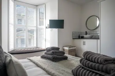 a living room with a couch and a mirror at Barmouth High Street Family Apartment in Barmouth